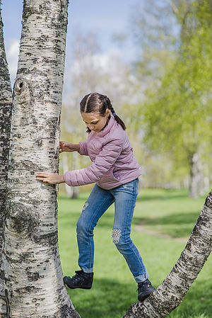 Mädchen klettert am Baum